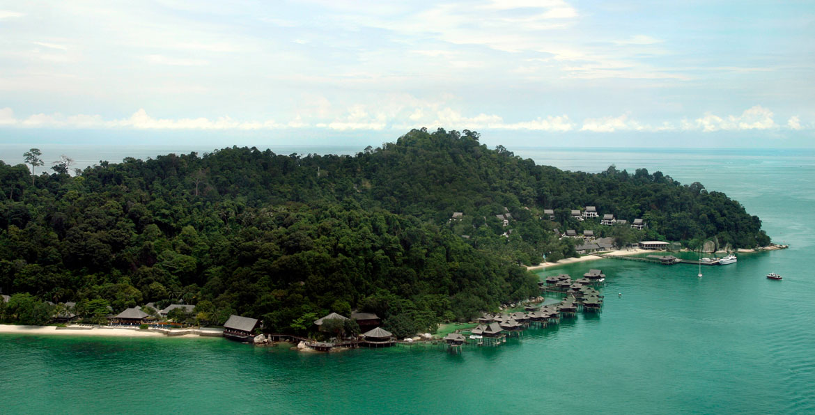 Drone view of overwater bungalows on small island