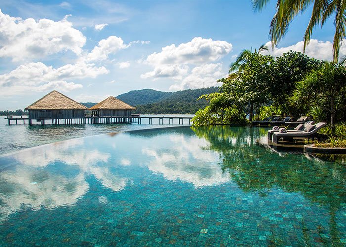 Infinity pool overlooking ocean surrounded by the jungle